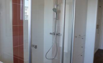 Salle de bain carrelée avec cabine de douche