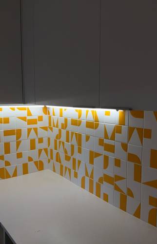 Crédence carrelage graphique orange, angle de cuisine avec éclairage LED intégré