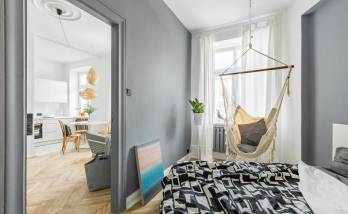 Chambre rénovée avec lit et chaise suspendue à Anduze 30140