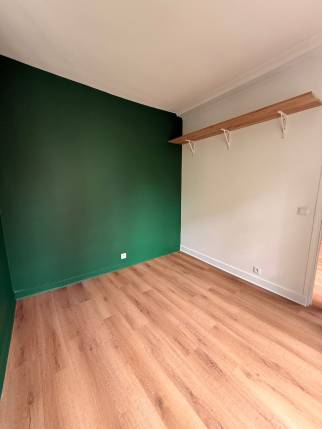 Espace nuit vert sapin avec étagère en chêne, studio rénové Paris 19