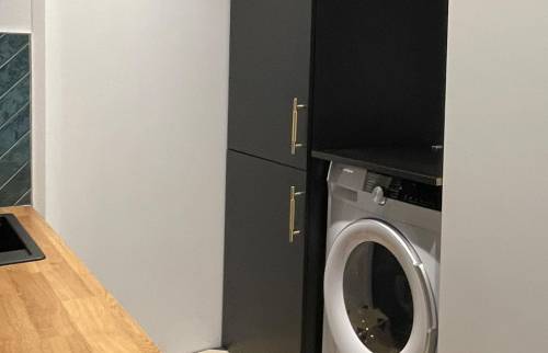 Face au plan de travail, le réfrégirateur et machine à laver le linge