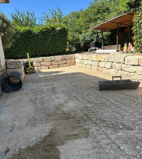 Cour prête à recevoir son revêtement final après terrassement, nivellement et mise en forme complète du terrain.