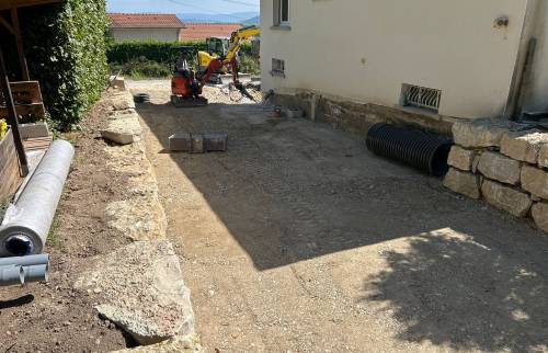 Alignement et pose des blocs de pierre pour la création d’un mur de soutènement esthétique et résistant.