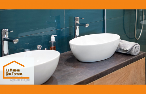 Lavabo poser sur un beau meuble avec un plan de travail noir et des portes affleurantes bois