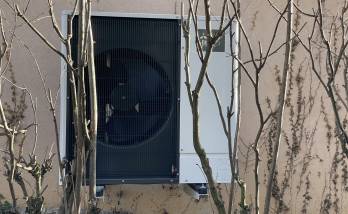 Installation extérieure, discrète, derrière la maison et camouflée par les arbustes