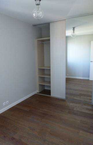 Rénovation du sol linoléum par lames de parquet PVC et intégration d'un dressing dans la chambre d'appartement ancien à Douarnenez (29)