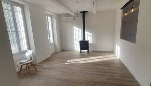 Salon rénové avec poêle à bois et ouverture cuisine