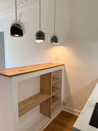 Étagères en chêne sous le bar de la cuisine ouverte, studio Paris 19