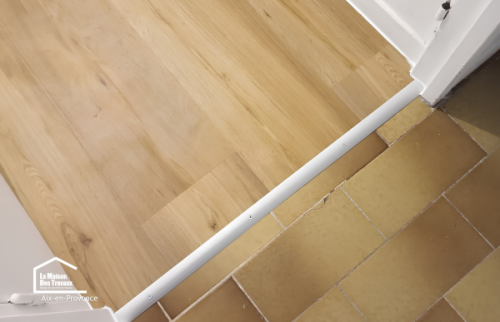 Détail des finitions du sol PVC imitation bois, une solution durable pour moderniser une salle de bains près d'Aix-en-Provence.
