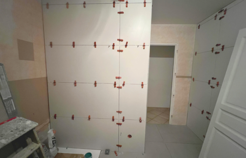 Phase chantier avec pose des grands carreaux muraux.