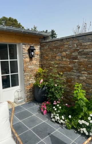 Détail de la baie vitrée avec le parement pierre, côté terrasse