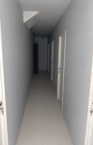 Sous sol de l'immeuble avec cloison et porte donnant aux box