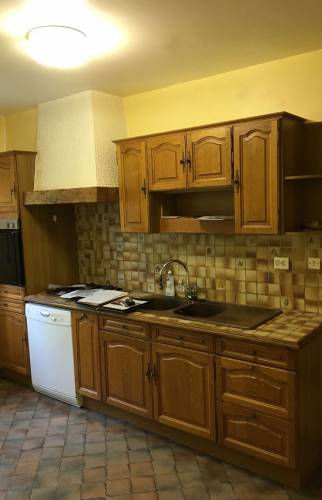 Cuisine ancienne avec meubles en bois et carrelage daté avant rénovation complète