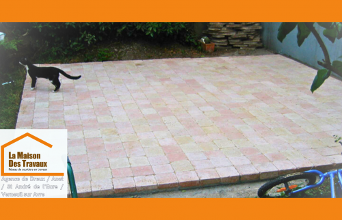 Terrasse en pierre rénovée à Dreux : un espace convivial pour profiter des beaux jours dans le jardin.