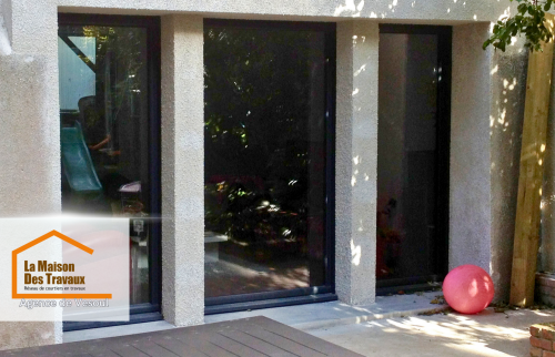 Rénovation extérieure avec baies vitrées à Luxeuil : Remplacement d’un mur ancien par de grandes ouvertures vitrées pour moderniser l’habitat et optimiser la lumière naturelle.