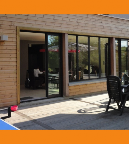 Extension bois moderne à Dreux avec large baie vitrée, réalisée par La Maison Des Travaux Dreux / Anet – confort et style garantis.