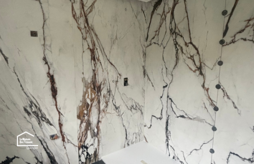Receveur de douche extra-plat et faïence effet marbre lors d'une rénovation de salle de bain à Quimper par La Maison Des Travaux.