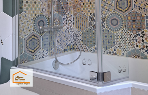 Rénovation de salle de bain entre Agen et Boé avec douche moderne, paroi vitrée et carrelage décoratif aux motifs géométriques pour une ambiance élégante et chaleureuse.