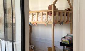 Chambre enfant avec lit cabane derrière verrière.