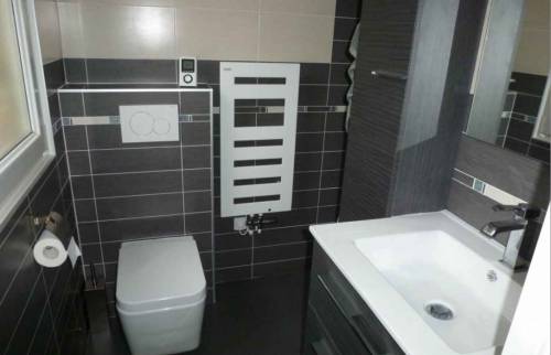 toilette suspendue dans salle de bain carrelée noire