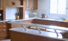 Cuisine en U avec meubles en bois massif et plan de travail blanc - rénovation à Bonneville (Haute-Savoie)