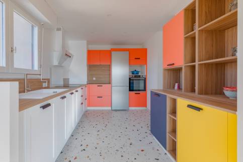 Cuisine multicolore dans un appartement de Lyon (69009) avec ouverture sur le séjour