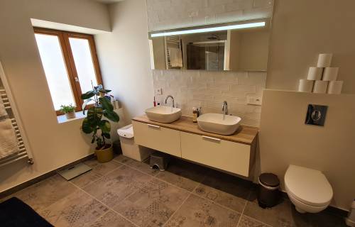 Le meuble vasque, le miroir et les toilettes