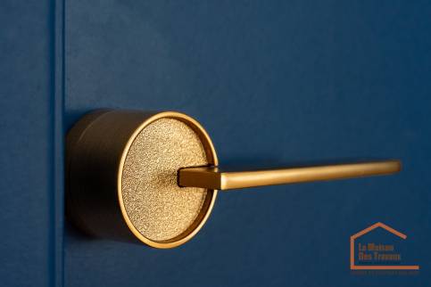 poignée dorée sur une porte peinte en bleu cobalt