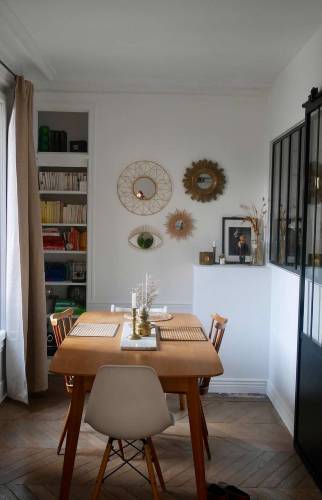 Salon avec verrière noire et porte coulissante.