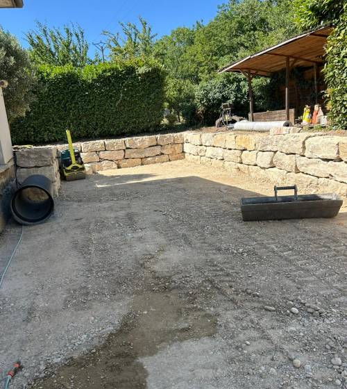 Cour prête à recevoir son revêtement final après terrassement, nivellement et mise en forme complète du terrain.