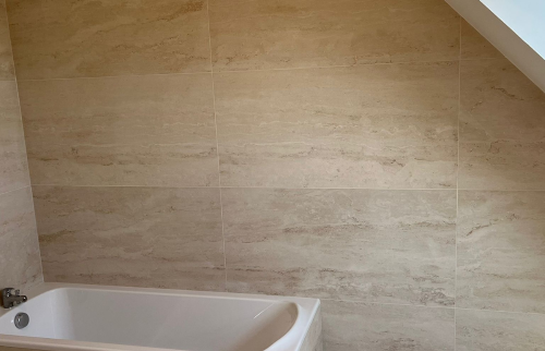 Détail des revêtements muraux en travertin dans la salle de bain rénovée