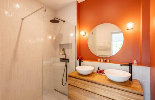 Salle de bain moderne avec mur terracotta et double vasque en bois, Paris 8e.