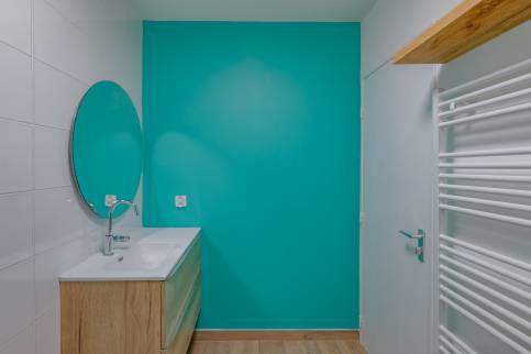 Salle de bains rénovée à Limonest ( 69760) : le mur peint en bleu qui répond au mur de la douche avec les faiences murales