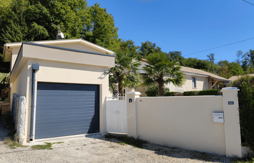 Nouveau garage avec porte sectionnelle gris anthracite et façade rénovée à Saint-Cassien.