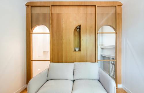 Paroi en bois clair séparant la salle de bain du salon à Paris 16e