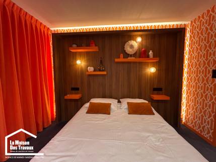 Vue d'ensemble d'une chambre parentale rénovée avec tête de lit en bois et rideaux orange.