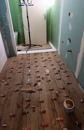 Pose du carrelage effet bois dans une salle de bain adaptée au maintien à domicile à Charancieu.