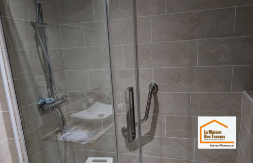 Douche sécurisée avec receveur extra-plat antidérapant, siège de douche et parois vitrées, réalisée lors d’une rénovation de salle de bain à Aix-en-Provence.