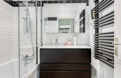 Rénovation d'un appartement ancien dans le coeur de Lyon : salle de bains avec meuble vasque et seche serviette noir mat 