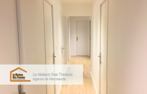 Un long couloir élégant aux murs blancs et aux portes assorties, qui met en valeur un parquet aux tons naturels. Ce couloir bien éclairé et épuré constitue un espace de transition agréable et fonctionnel, donnant un style moderne et raffiné à l'ensemble.