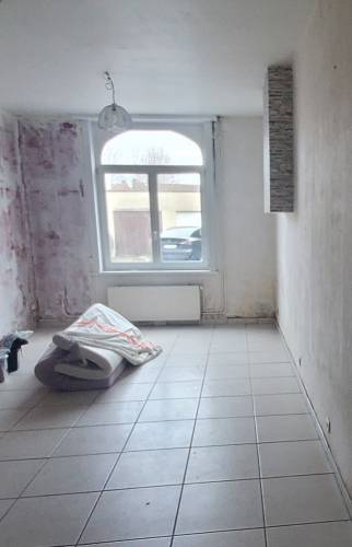 Salon à Harnes avant la démolition d'une cheminée rustique.