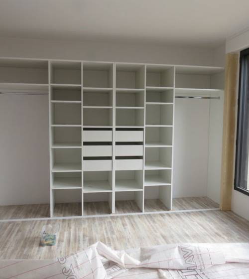 Structure intérieure d'un dressing d'entrée sur mesure avec penderies doubles et rayonnages optimisés.
