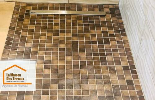 Détail du receveur de douche à l’italienne en mosaïque antidérapante, avec caniveau inox discret, réalisé par La Maison Des Travaux de Vesoul.