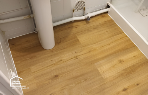 Pose soignée d'un revêtement de sol PVC autour de la douche lors d'une rénovation de salle de bains dans le Pays d'Aix.