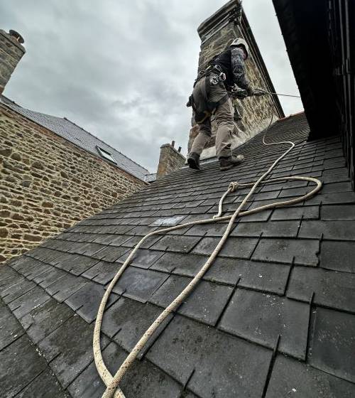 Intervention en toiture avec mise en sécurité par cordage, réalisée par un couvreur spécialisé dans les travaux en hauteur afin d’accéder à la zone d’infiltration.