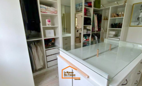 Dressing sur mesure avec îlot central vitré, rangements ouverts et penderies intégrées – aménagement intérieur en Haute-Savoie.