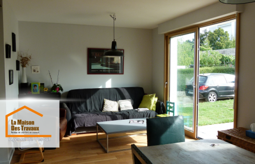 Salon rénové près de Luxeuil – Espace cosy avec grande baie vitrée, parquet chaleureux et décoration épurée pour un intérieur lumineux et agréable.