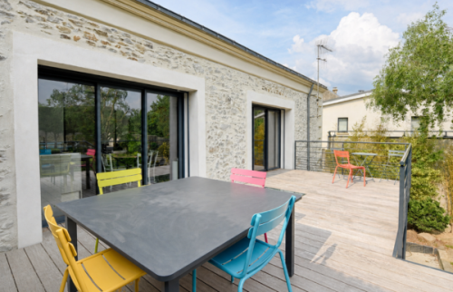 Vue extérieure de la maison à Sainte-Bazeille avec terrasse en bois, dans le cadre d’un projet de rénovation accompagné par La Maison Des Travaux Marmande.