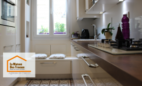 Cuisine rénovée à Luxeuil avec meubles laqués blancs et éclairage LED intégré, offrant un design moderne et lumineux.