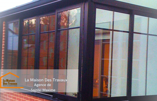 La base en briques est montée pour assurer une intégration parfaite avec la maison, tandis que la structure en aluminium prend forme.  